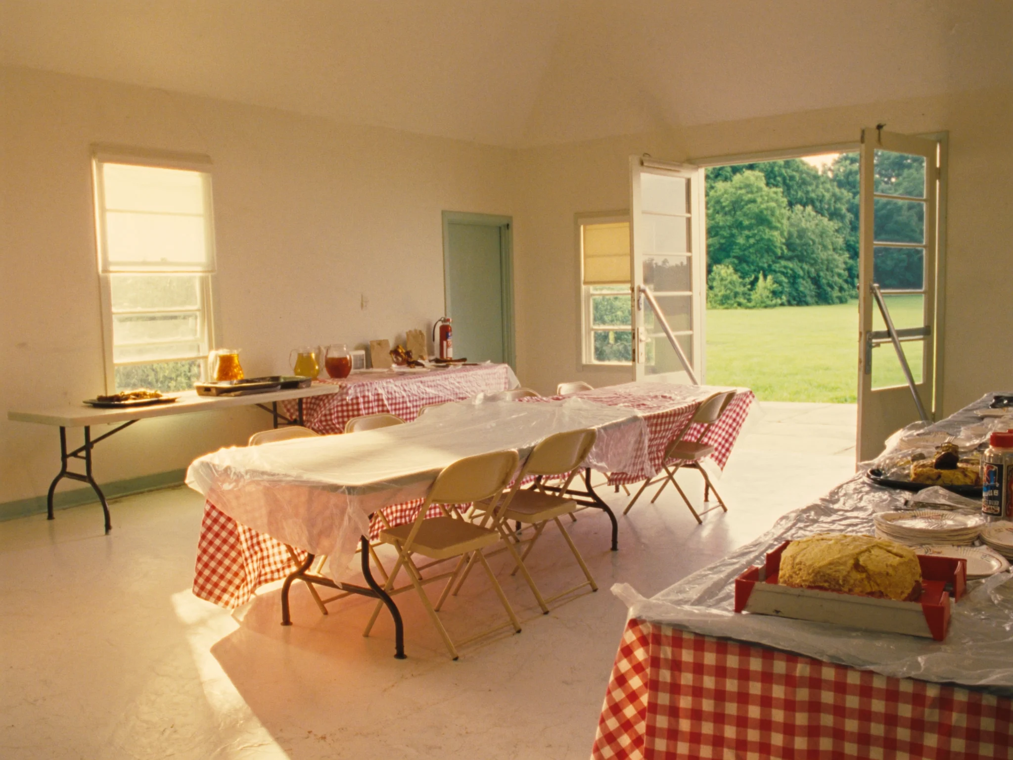 Fellowship hall tables set with checked cloths and a sheet cake for the annual Sunday school picnic