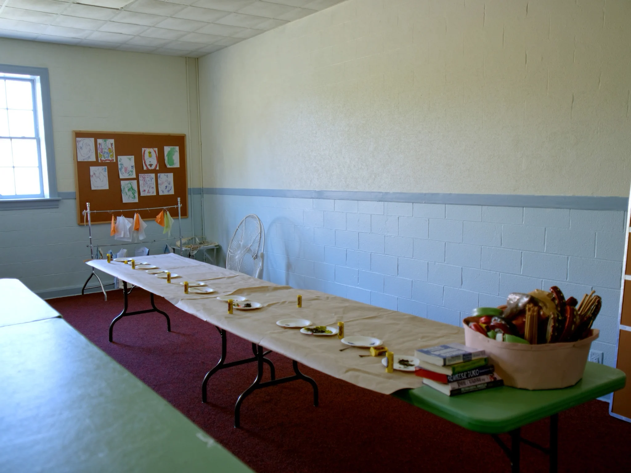 A children's ministry craft table set up with paint, glue and construction-paper projects